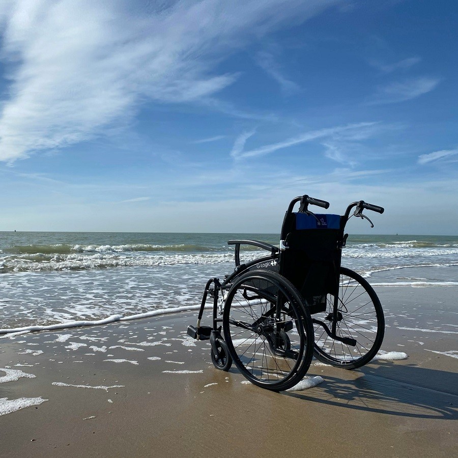 Rollstuhl am Strand. Wenn die Krankenkasse solche Hilfsmittel verweigert, kann unser Anwalt helfen.